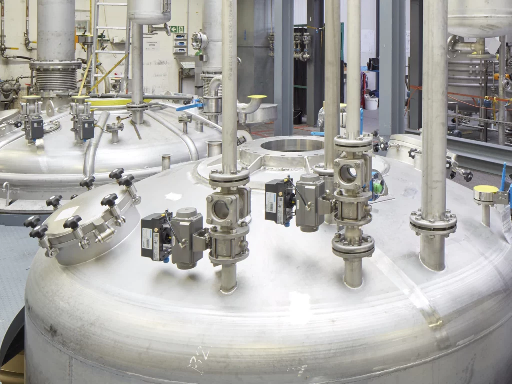Zwei Reaktoren für die Klebstoff-Polymerisierung im Aufbau, an den Zuleitungen sind die Regelarmaturen (Kugelsektorventile) bereits montiert.